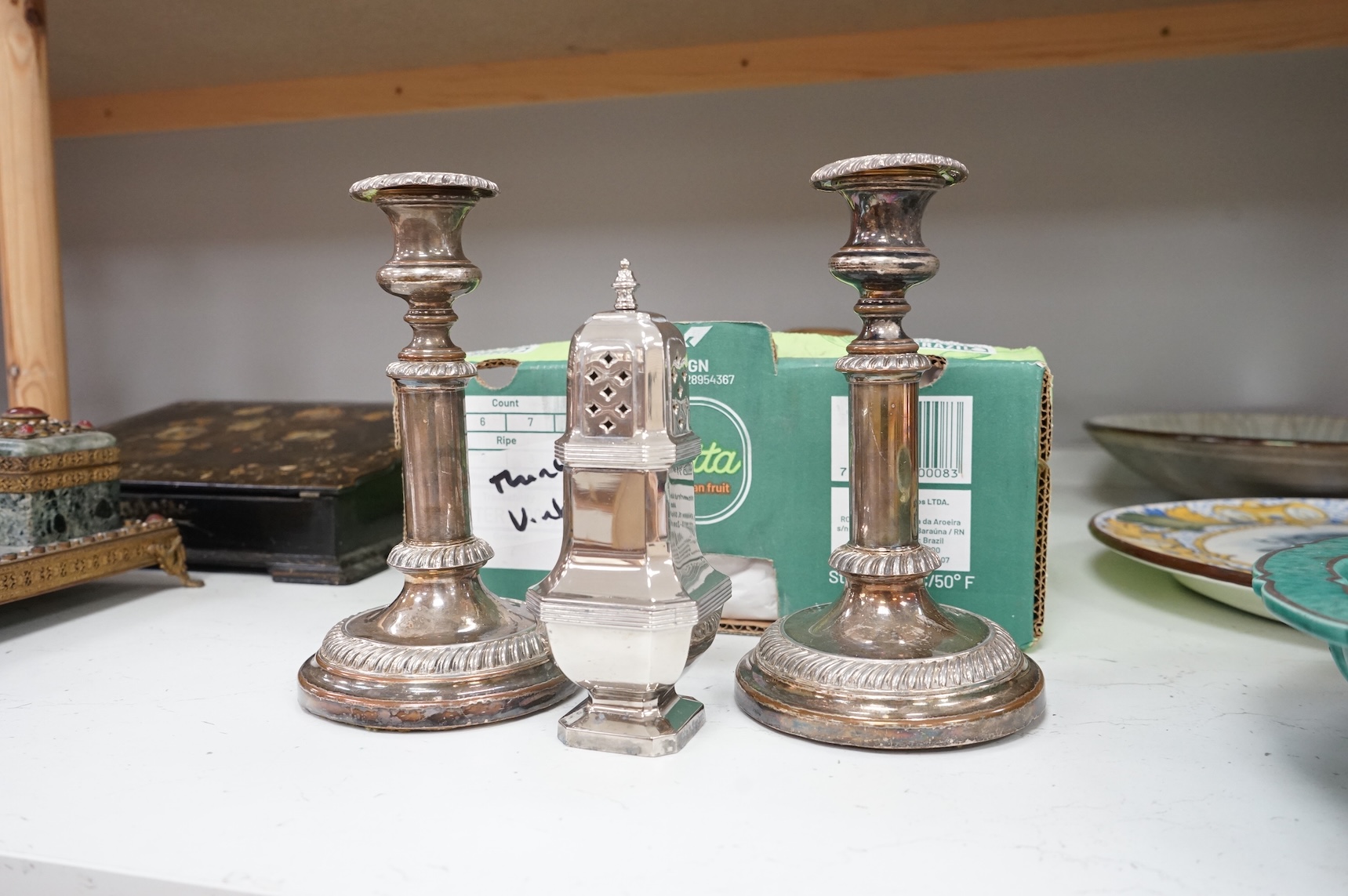 A collection of small plated wares including a pair of candle sticks, cruets, cutlery, sugar shaker, etc